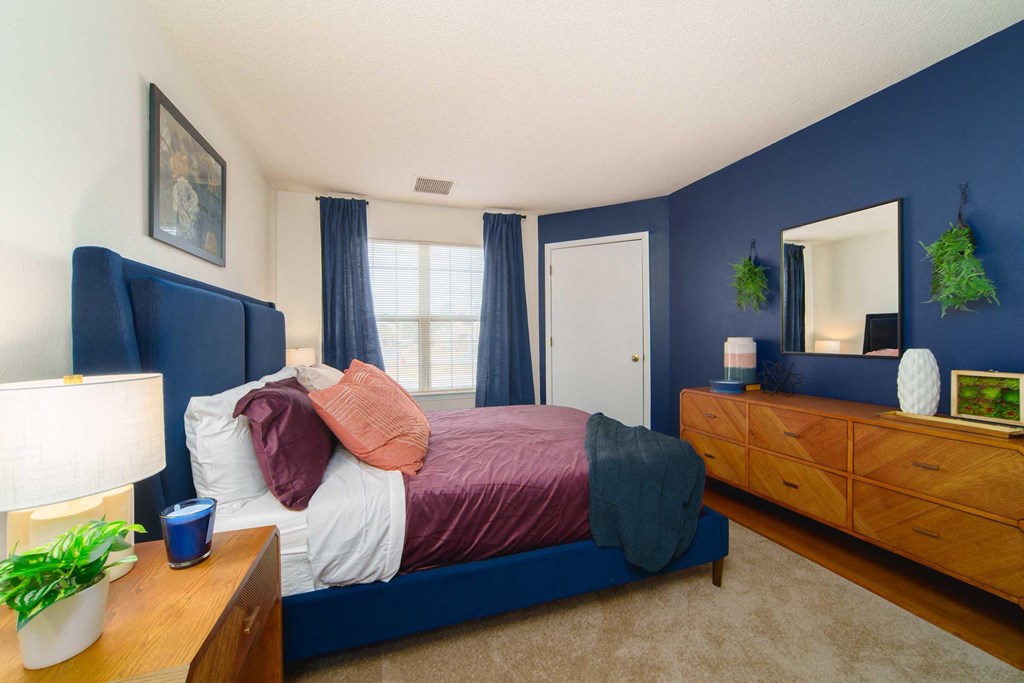 a bedroom with a bed and a dresser and a window