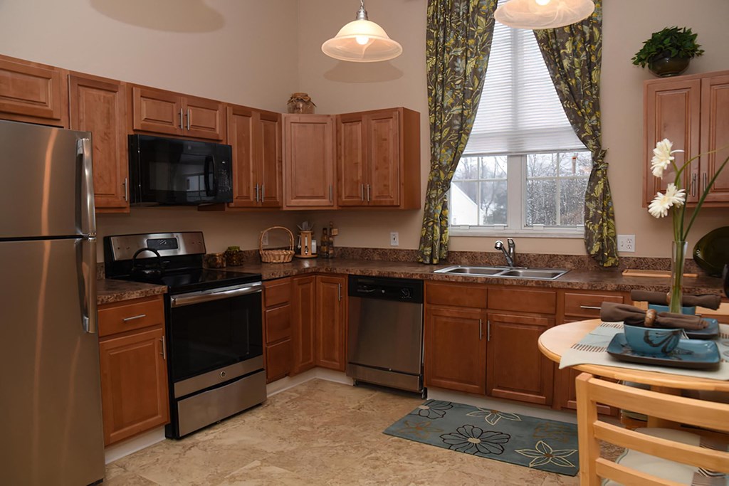 a kitchen with wooden cabinets and stainless steel appliances