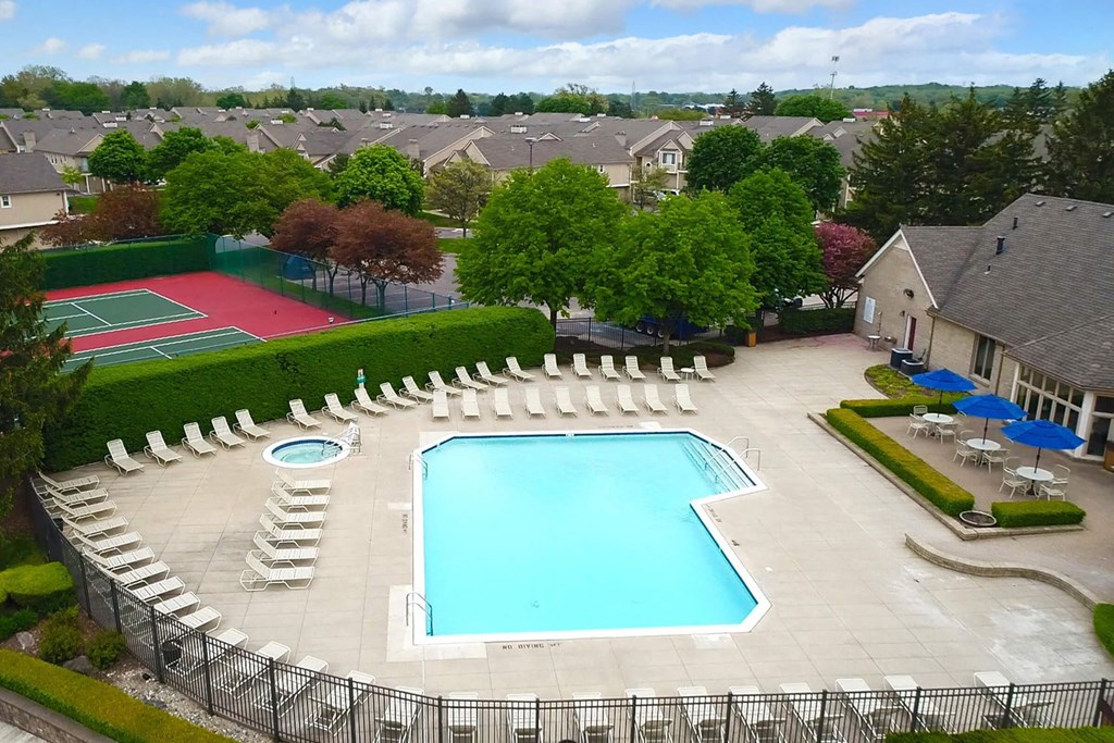 an aerial view of a swimming pool with chairs around it