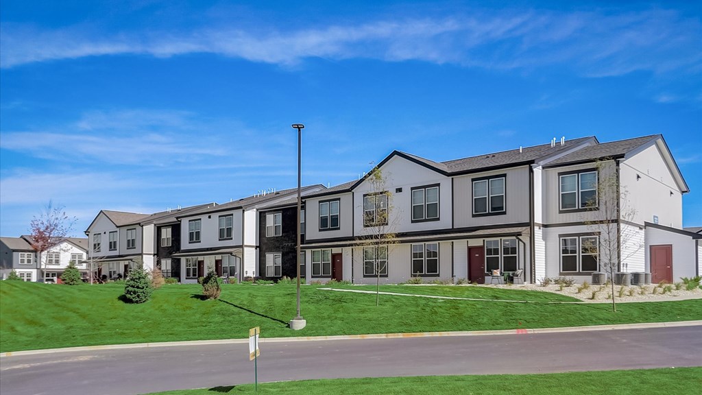A row of townhouses with a clear blue sky above.