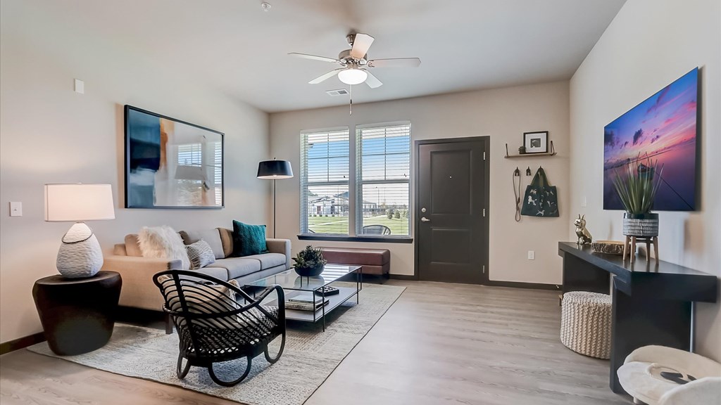 A living room with a black rocking chair and a white sofa.