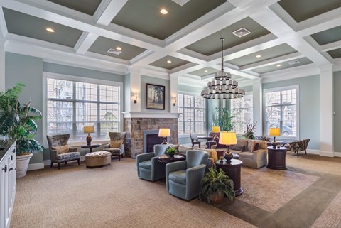 A large, well-lit living room with a variety of seating options and a chandelier at Meridian West Shore, Pennsylvania 17055