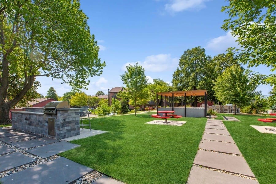 A park with a stone structure and picnic tables.