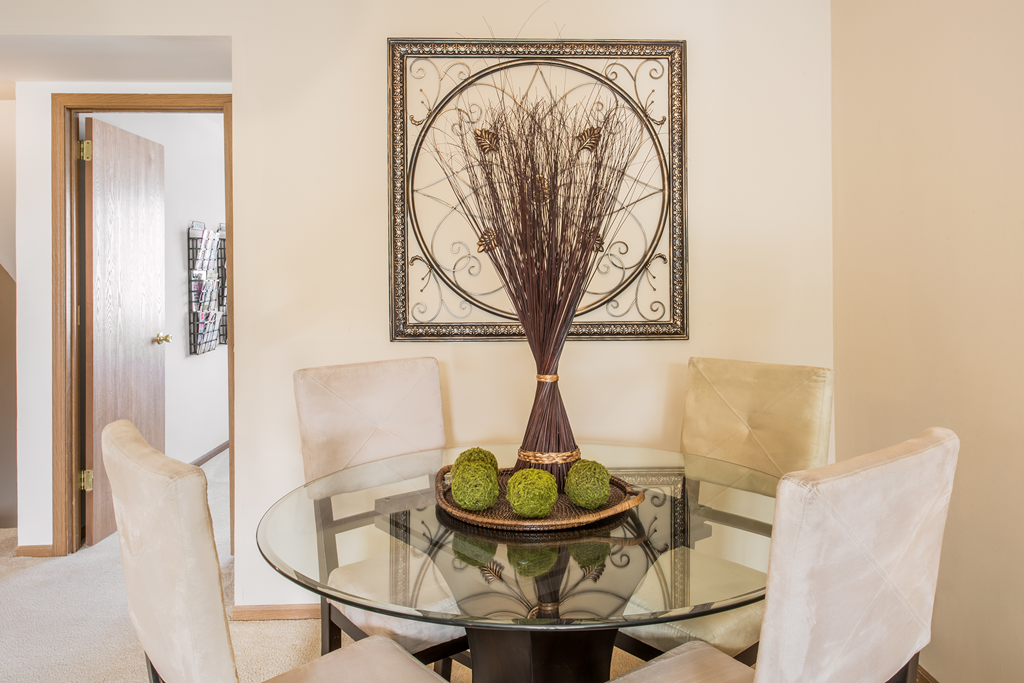 a dining room with a glass table and chairs