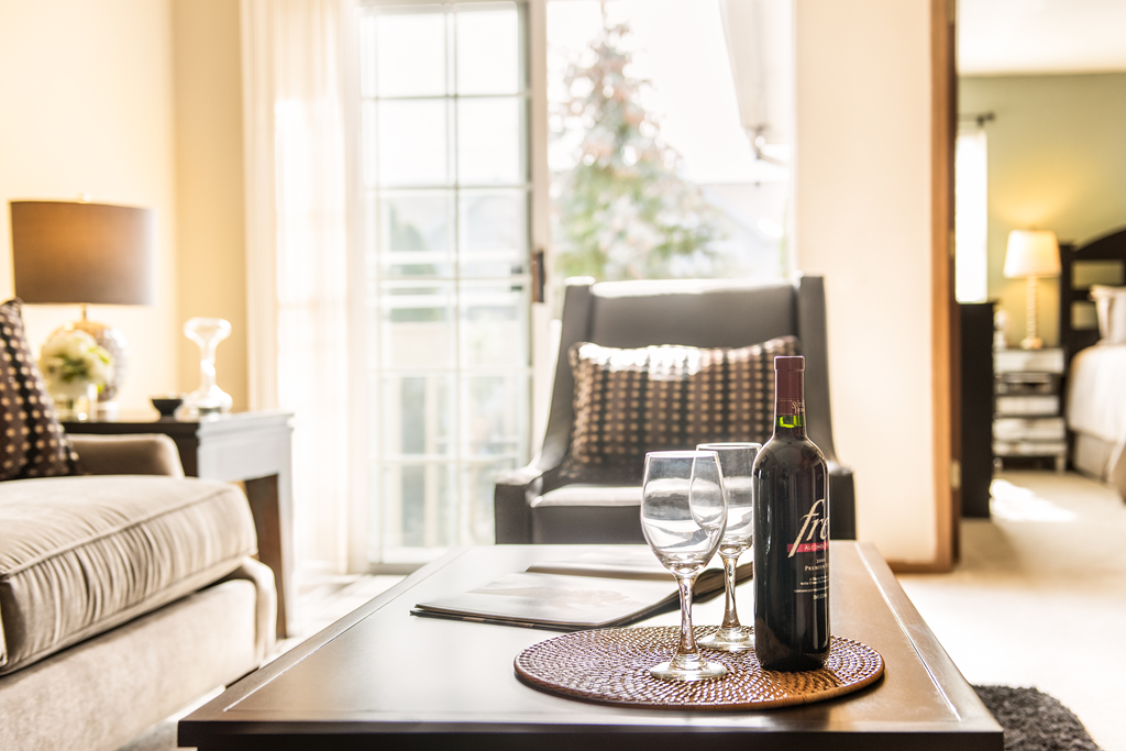 a bottle of wine and two glasses on a table in a living room