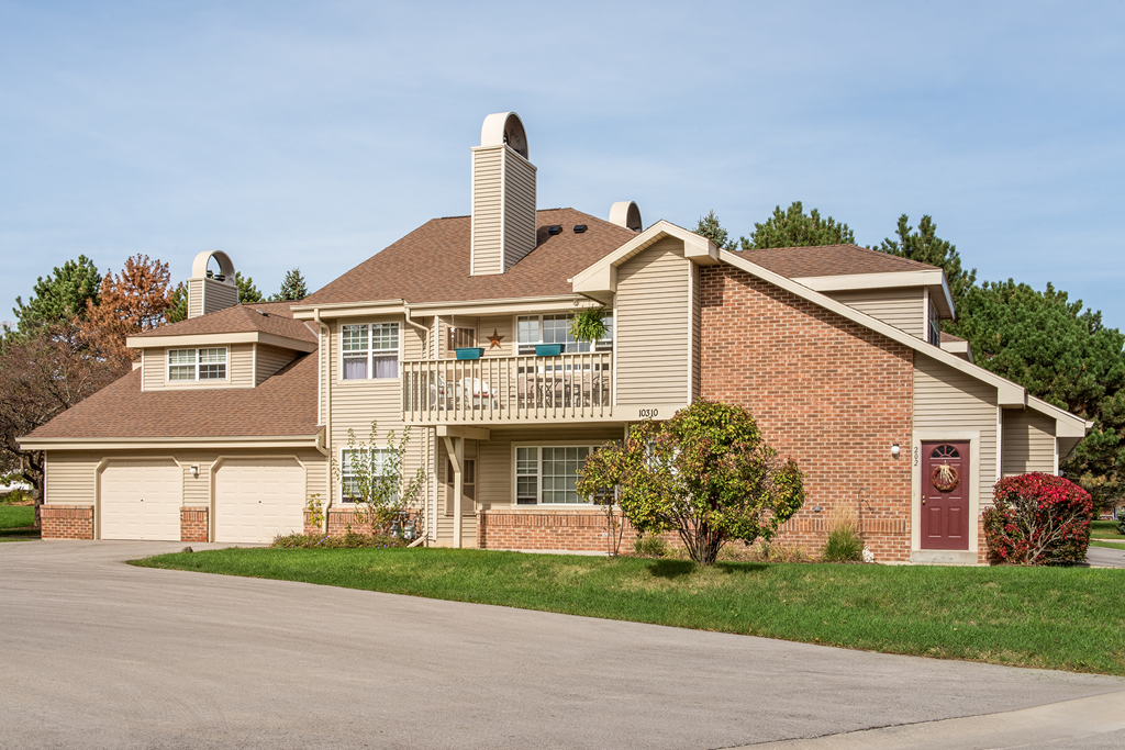 a brick house with a balcony and a driveway