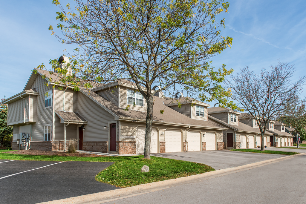 a street view of a row of houses with garages