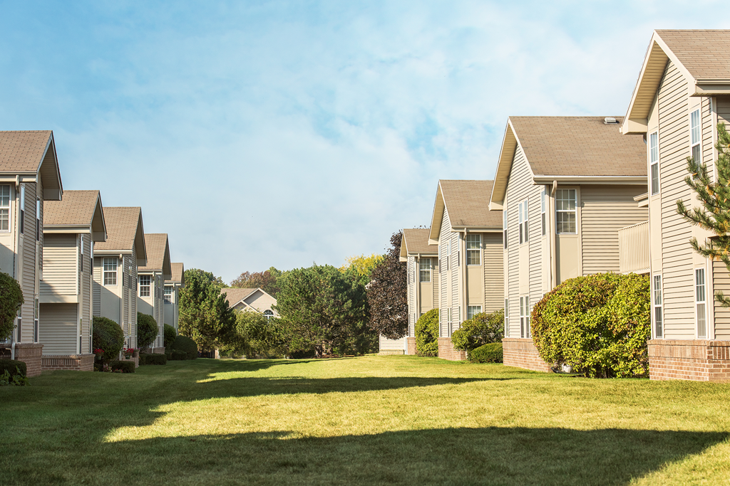a row of houses on a green lawn