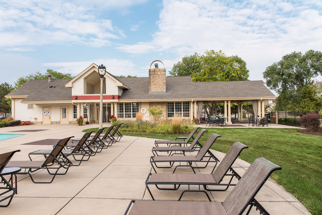 the backyard of a house with patio furniture and a pool