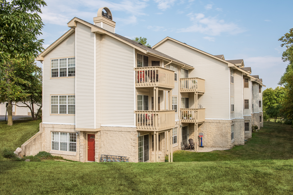 a building with two balconies on the side of a hill