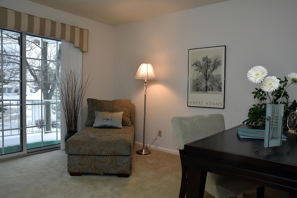 a living room with a chair and a desk