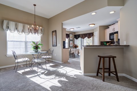A sunny day in a well-lit living room with a dining table and chairs.