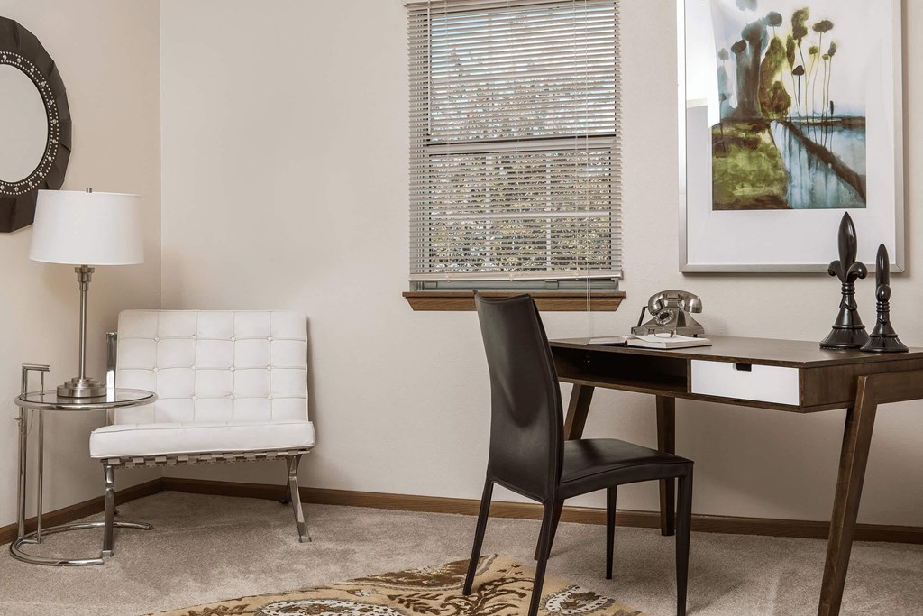 a desk in a room with a chair and a table