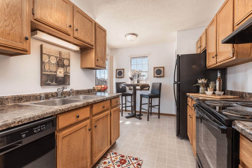 a kitchen with wooden cabinets and a black refrigerator