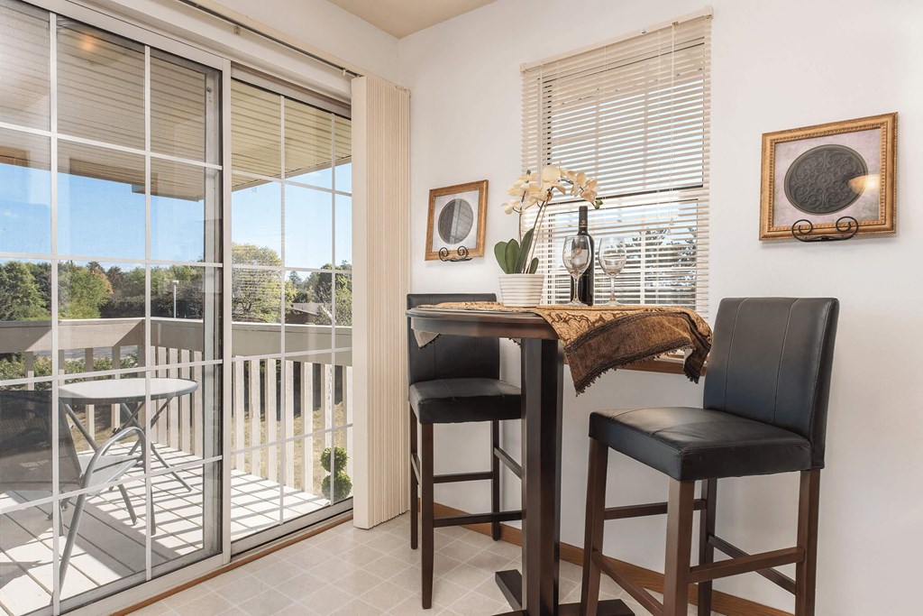 a bar table with two chairs in a room with a balcony