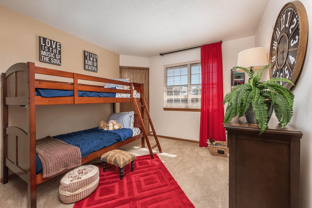 a bedroom with bunk beds and a large clock on the wall