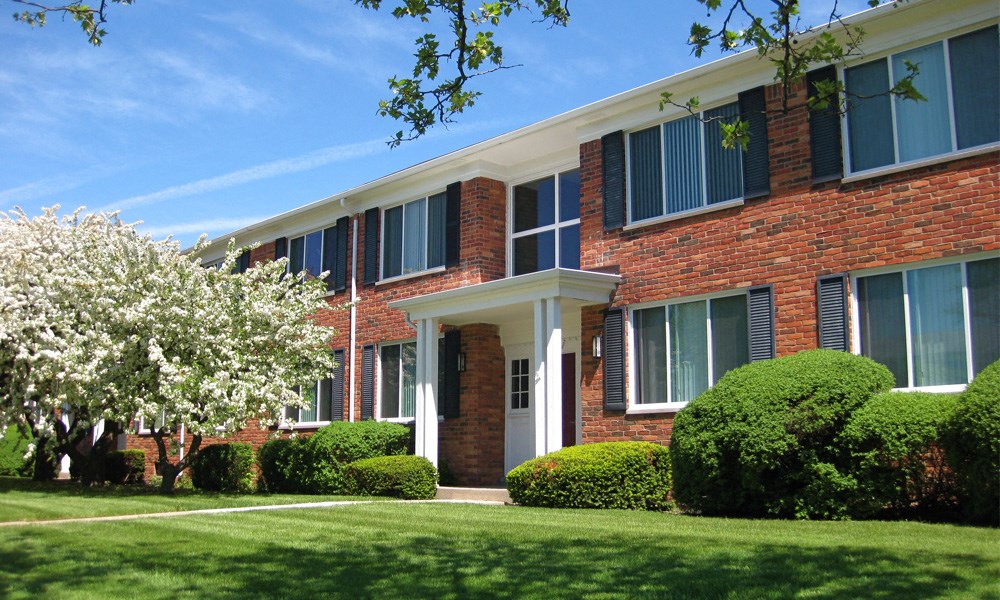 A red brick building with a white door and windows.