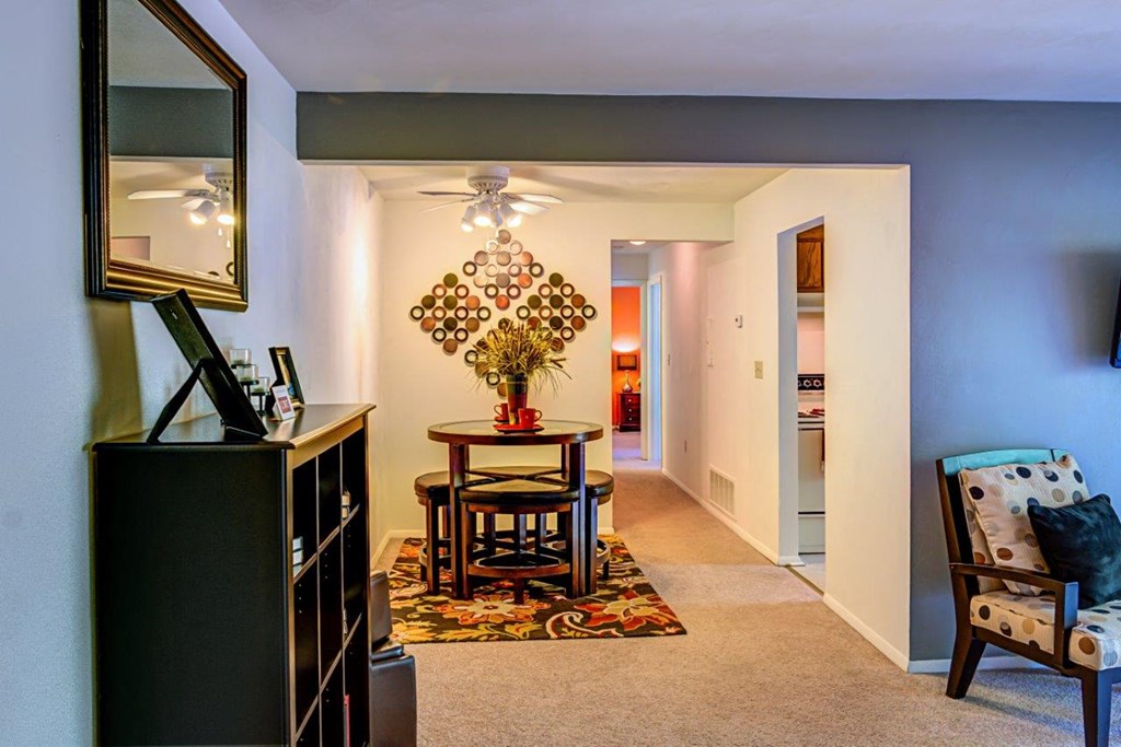 a living room with a table and a hallway with a door