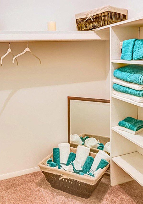 a closet with towels in it and a mirror