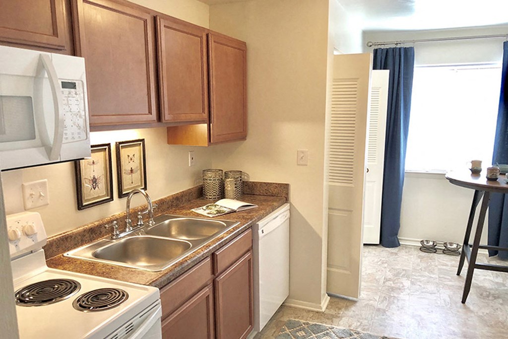a kitchen with a sink and a stove and a microwave