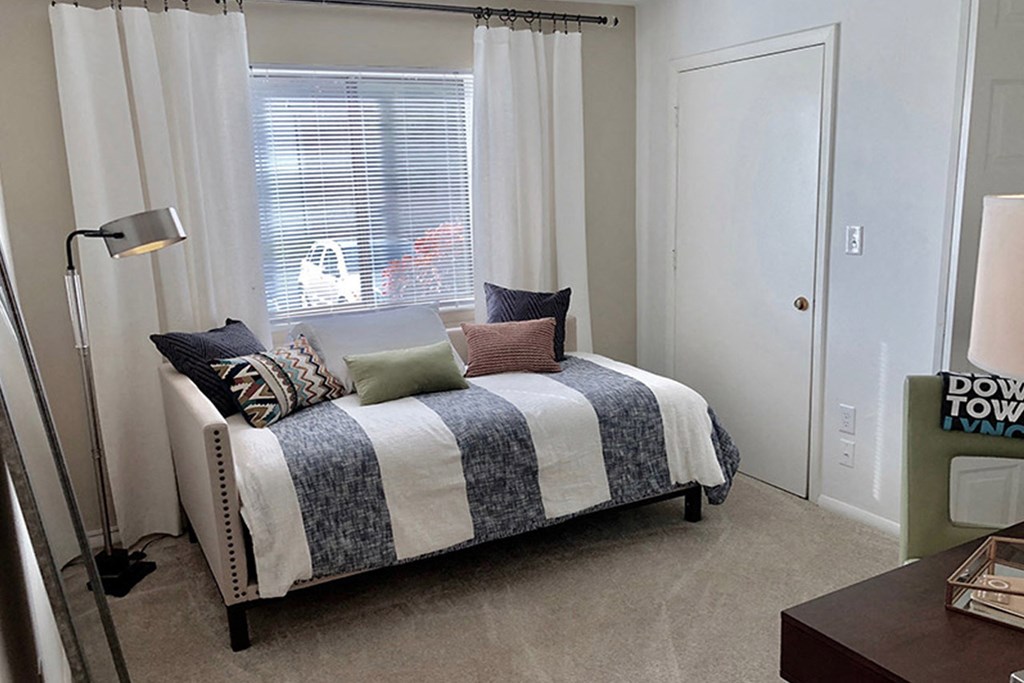 a small bedroom with a bed and a window