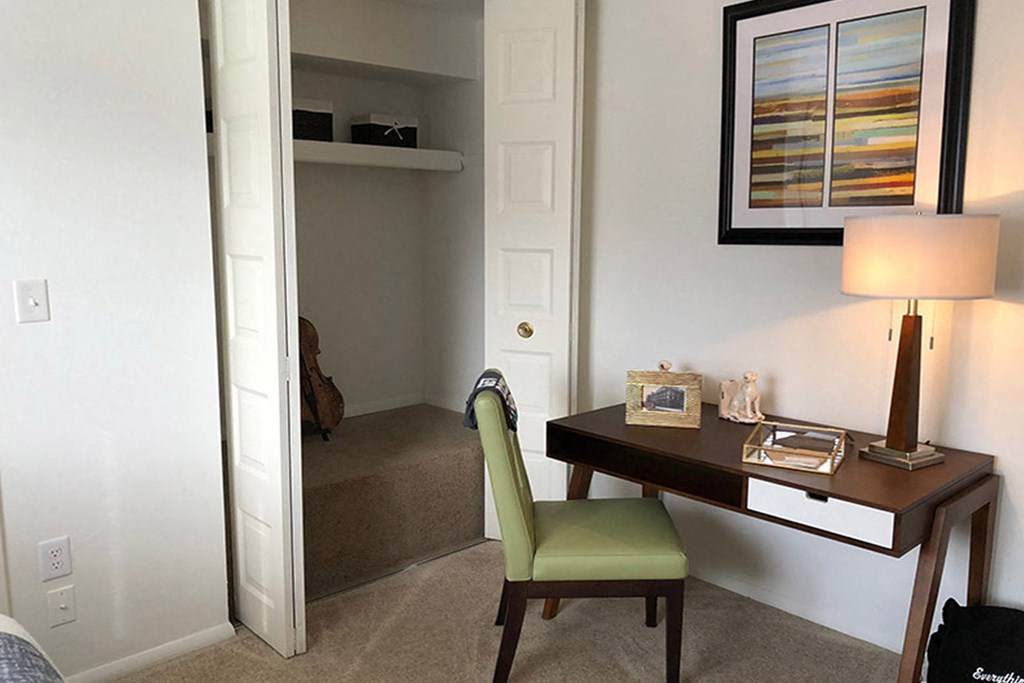 a desk with a lamp and a chair in a hotel room