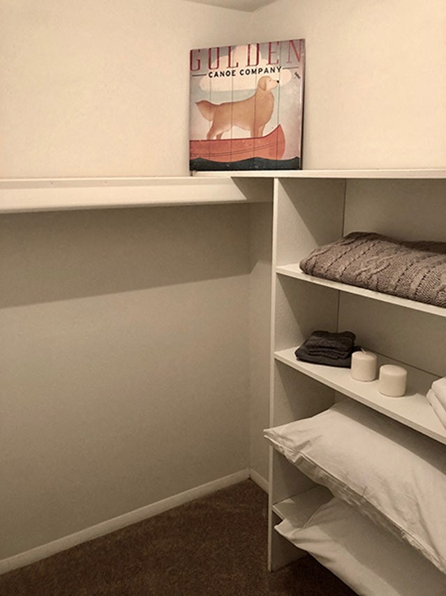 a closet with shelves and pillows and a poster on the wall