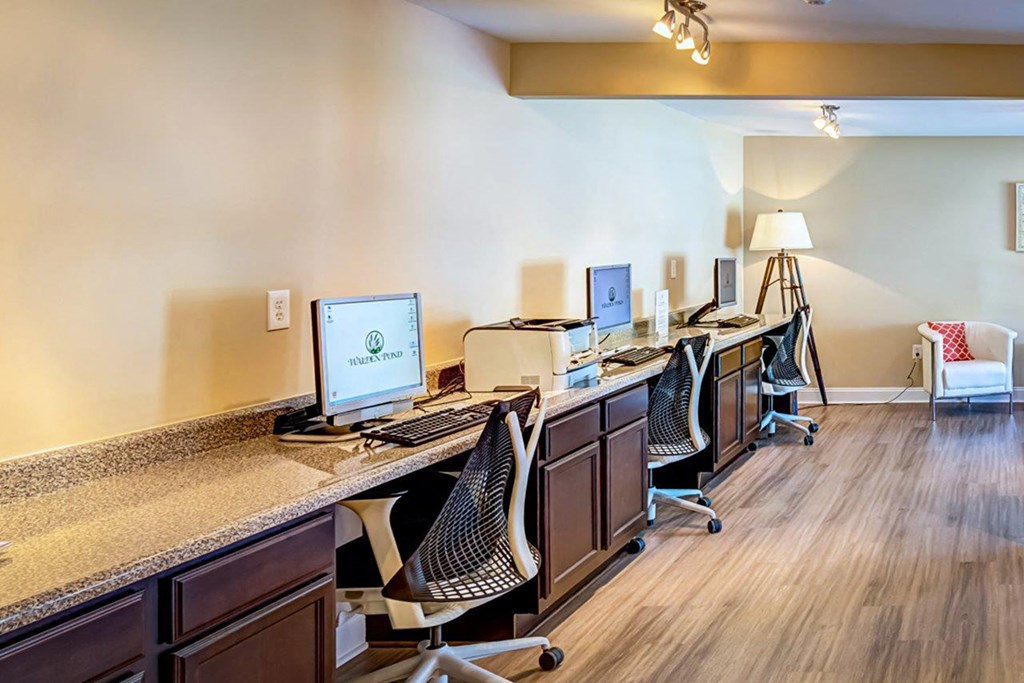 a row of desks with computer monitors in a room