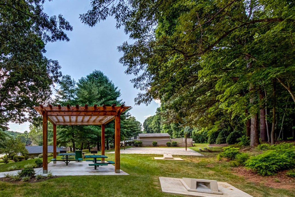 a picnic area with a pavilion and benches in a park