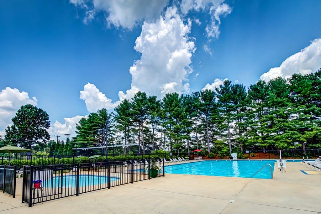 a swimming pool with trees and a fence around it