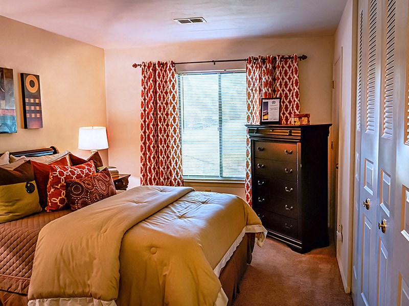 a bedroom with a bed and a dresser and a window