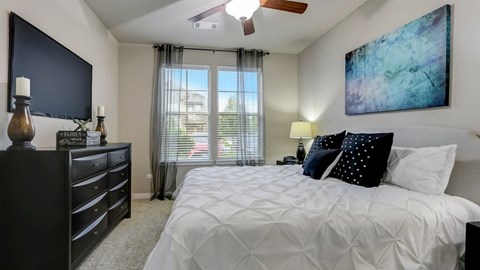 Modern bedroom with natural light and artwork at Reserve at Romeoville, Romeoville, IL
