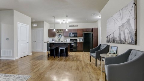A modern living room with a wooden floor and a large grey sofa.