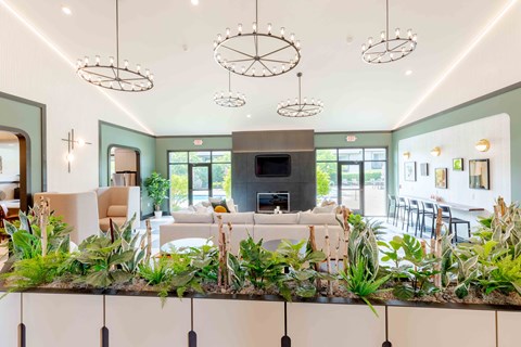 A living room with a fireplace and a long table with chairs.