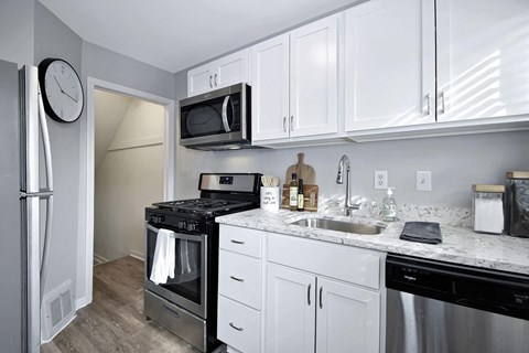 a kitchen with stainless steel appliances and white cabinets