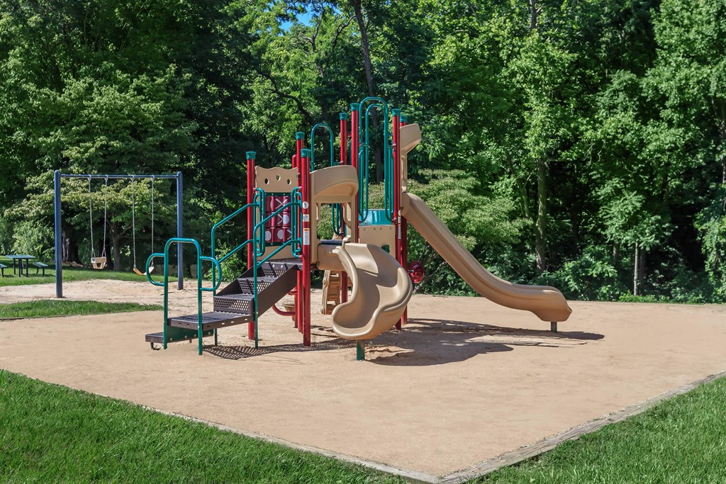 a playground with a set of slides in a park