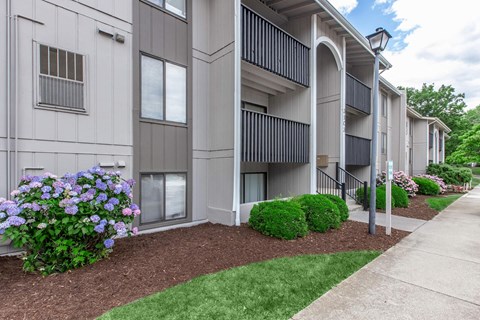 an exterior view of a building with flowers and grass