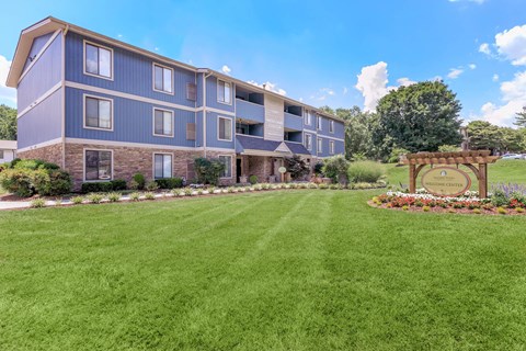 a large lawn in front of a building with a sign