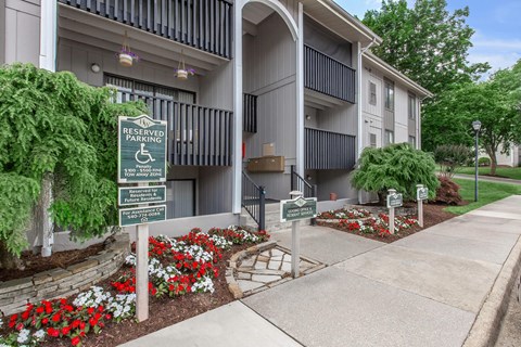 a building with a sidewalk and signs in front of it