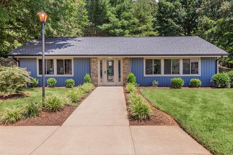 a blue house with a sidewalk in front of it