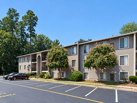 Apartment building with a parking lot in front.
