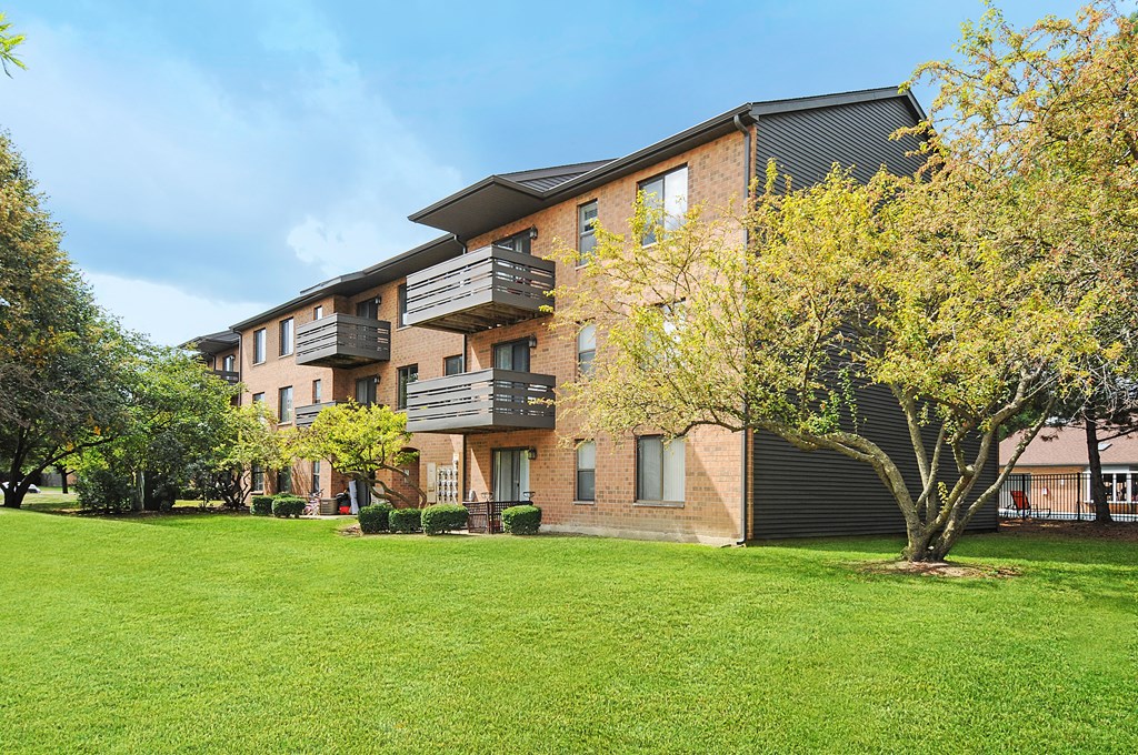 A large grassy area in front of apartment buildings.