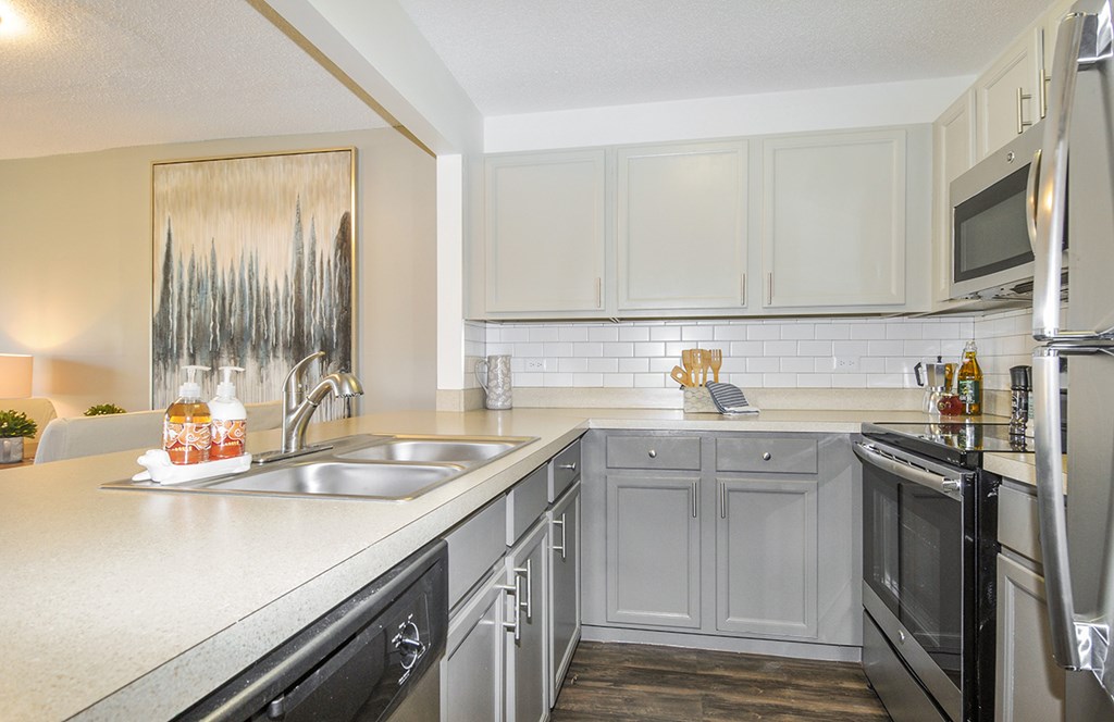 A kitchen with black appliances and white cabinets.