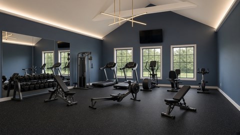 A spacious gym with a variety of equipment and a flat screen TV mounted on the wall.