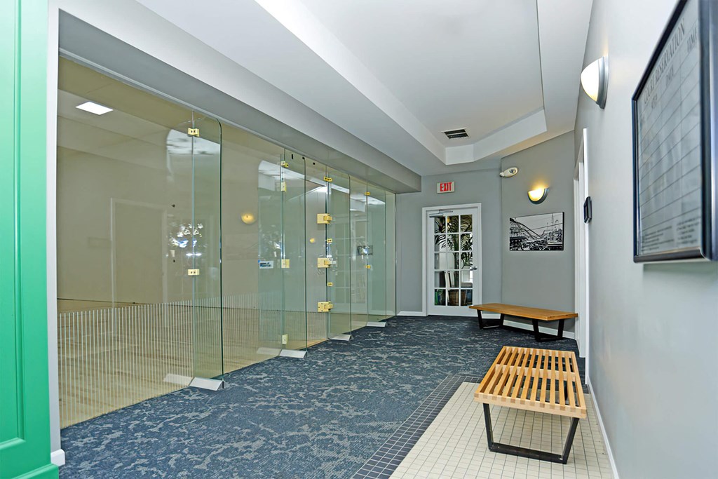 a large lobby with glass doors and a blue carpet