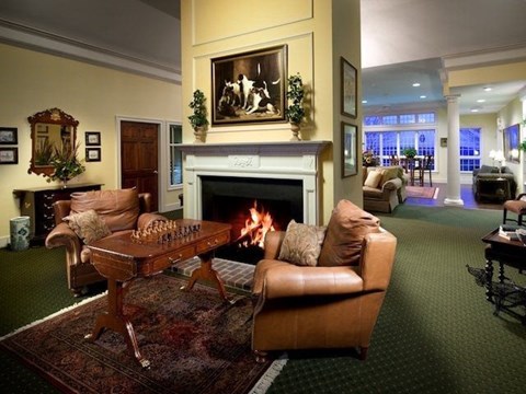 A living room with a fireplace and a painting above it.