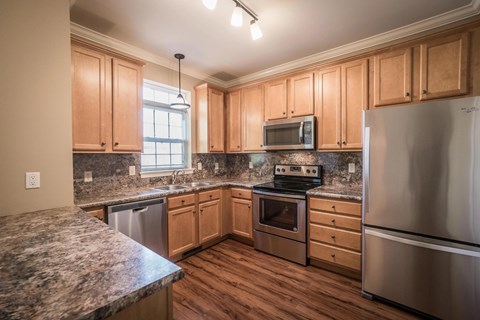 A kitchen with wooden cabinets and stainless steel appliances.