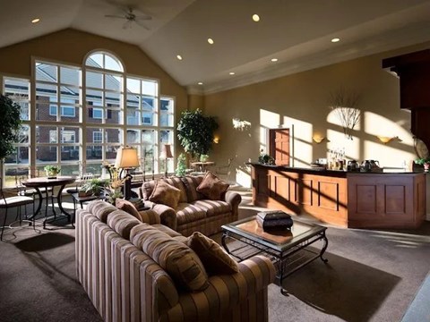 A living room with a striped couch and a ceiling fan.