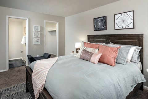 A bedroom with a large bed and two wall art pieces.