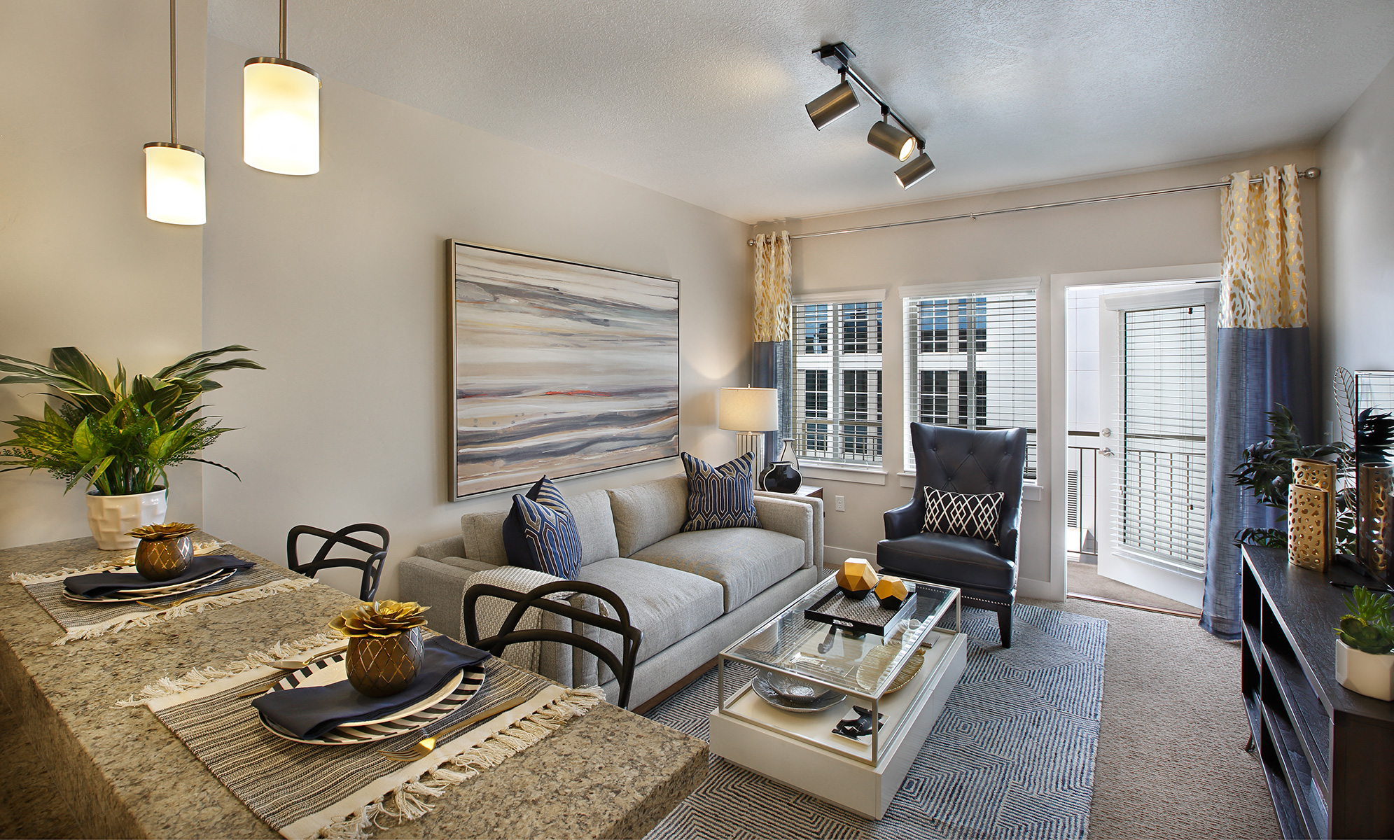 A modern living room with a grey sofa, a coffee table, and a painting on the wall.